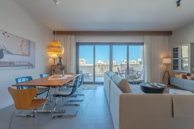 a living room with a couch and a table and chairs at Boutique 2BR in Fanadir Marina - El Gouna. Lagoons & Red Sea in Hurghada