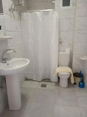 a bathroom with a white shower curtain and a toilet at Pool view studio with terrace in Hurghada