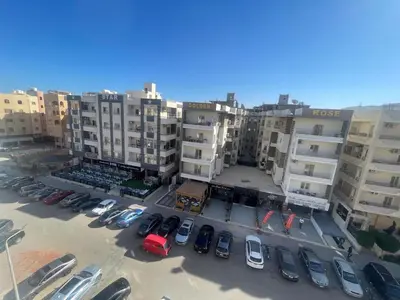 an aerial view of a parking lot with cars in front of buildings at Modern HOME DownTown in Hurghada