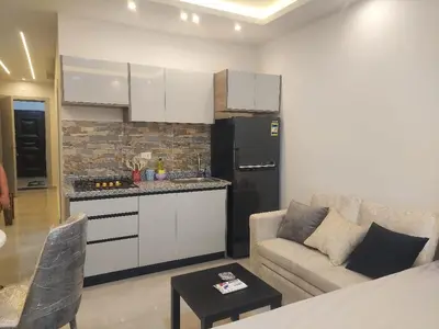 a living room with a couch and a kitchen at Makramia New Studio near to the beach in Hurghada