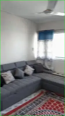 a living room with a gray couch and a window at 