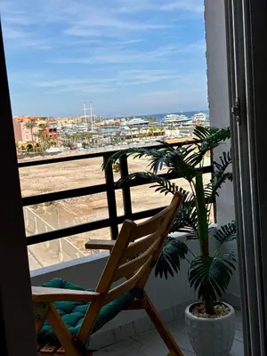 a chair and a potted plant on a balcony at Marina View Apartment in Hurghada