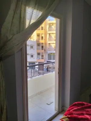 an open window with a view of a building at Eldon apartment in Hurghada