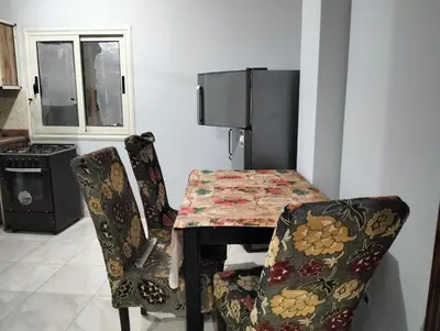 a kitchen with a table and two chairs and a table and a table and chairs at Eldon apartment in Hurghada
