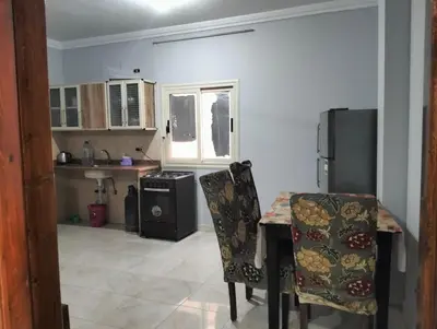 a kitchen with a table and chairs and a refrigerator at Eldon apartment in Hurghada