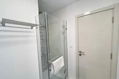 a bathroom with a shower and a glass door at Charming & Beautifully Styled 3BDR Swan Lake Gouna in Hurghada