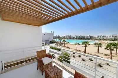 a balcony with chairs and a view of the beach at Charming & Beautifully Styled 3BDR Swan Lake Gouna in Hurghada
