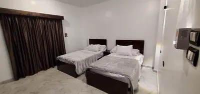 a hotel room with two beds and a window at Elminaa Residence 6 in Luxor