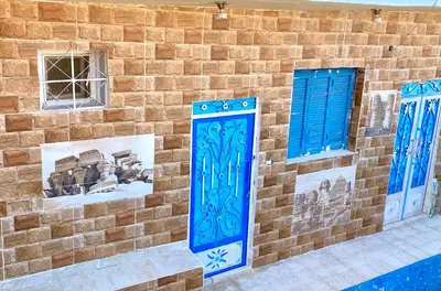 a brick wall with blue doors and windows at Bakar House in Aswan