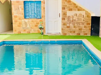 a swimming pool in front of a house at Bakar House in Aswan