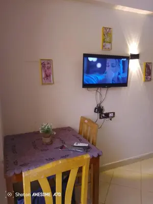 a dining room table with a television on the wall at Florenza khamsin compound unit g4 in Hurghada