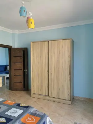 a large wooden cabinet in the corner of a room at Schöne Europäische 3 Zimmer Wohnung in Al Dahar in Hurghada