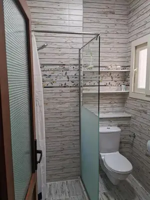 a bathroom with a toilet and a glass shower at Schöne Europäische 3 Zimmer Wohnung in Al Dahar in Hurghada
