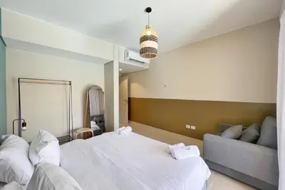 a bedroom with a large white bed and a couch at Smooth & Snug 1 BDR Mangroovy Free Beach & Pool Access in Hurghada