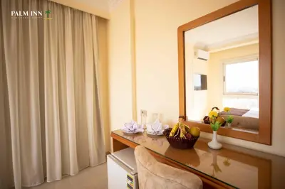 a room with a mirror and a table with a chair at Palm Inn Hotel Hurghada in Hurghada