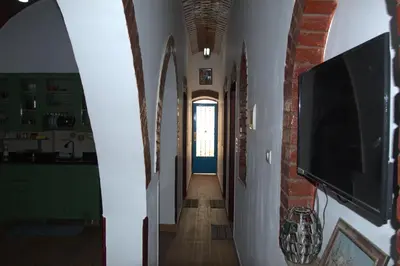 a hallway of a house with a television and a door at Mogran Guest House in Luxor