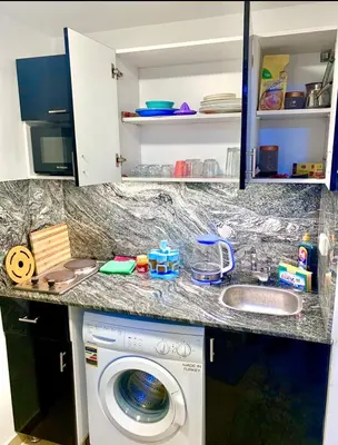 a kitchen counter with a washing machine and a sink at Sunny studio with 3 swimming pools Florenza Hurghada in Hurghada