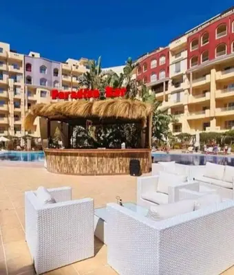 a resort with white chairs and a gazebo at Sunny studio with 3 swimming pools Florenza Hurghada in Hurghada
