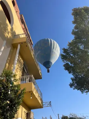 a hot air balloon flying next to a building at Karima House in Luxor