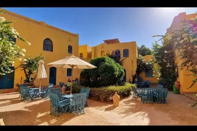 a group of chairs and an umbrella in front of a building at Cozy apartment in Downtown Gouna in Hurghada