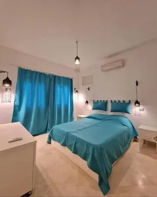 a bedroom with a blue bed and blue curtains at Cozy apartment in Downtown Gouna in Hurghada