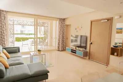 a living room with a couch and a television at Cozy 1 Bedroom Ground Floor Apartment with Pool in Hurghada