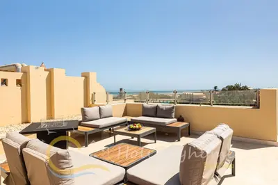 a patio with couches and tables on a balcony at 2-BR Penthouse with roof terrace in Abu Tig Marina in Hurghada
