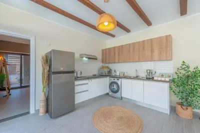 a kitchen with a stainless steel refrigerator and a table at Tropical 2BR Paradise in Bali, El Gouna. Pool, Patio & BBQ in Hurghada