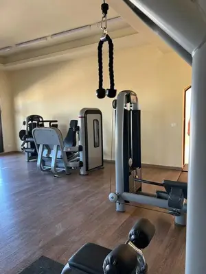 a gym with a bunch of equipment in a room at 2 bedroom modern flat at Makadi heights in Hurghada
