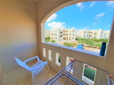 a balcony with a chair and a view of a building at 2 bedroom modern flat at Makadi heights in Hurghada