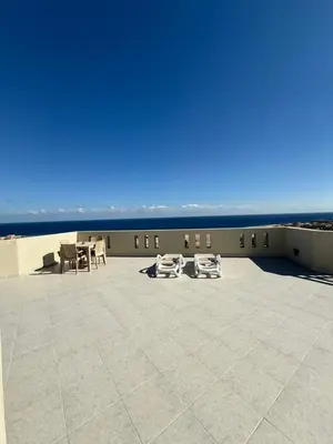 a patio with chairs and tables on the beach at Roof top apartment with panorama view in Hurghada