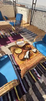 a table with plates of food on the beach at king kassem nubian guest house in Aswan
