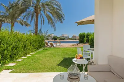 a patio with a table and a view of the water at Cheerful space with a huge garden and pool in Hurghada