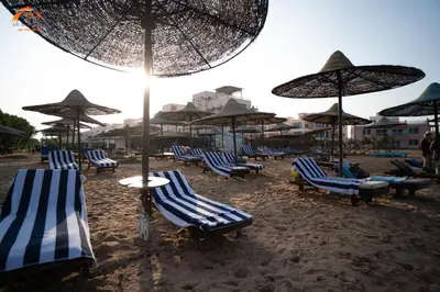 a group of chairs and umbrellas on a beach at FOX SAHEL AQUA RESORT ELGOUNa& Kite in Hurghada