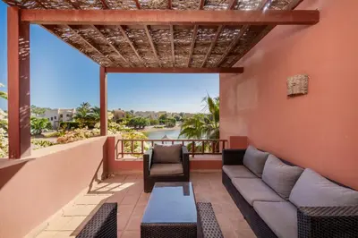 a living room with a couch and a chair on a balcony at 3-Bedroom Apartment - Great location- Upper Nubia in Hurghada