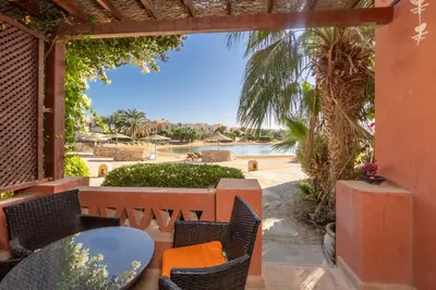a patio with a table and chairs and a pool at 3-Bedroom Apartment - Great location- Upper Nubia in Hurghada