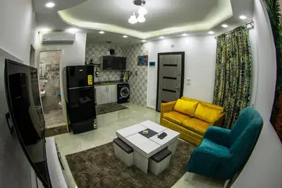 a living room with a yellow couch and a table at Inter Prime apartment 3 in Hurghada
