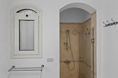 a bathroom with a shower with a window and a mirror at The Seafront Magical Loft! in Hurghada