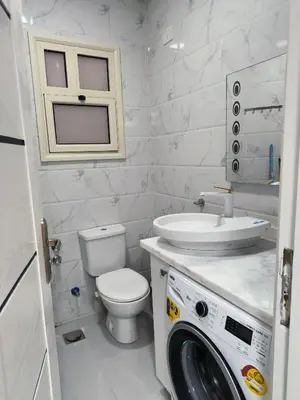 a bathroom with a toilet sink and a washing machine at Juliana beach studio front of the beach in Hurghada