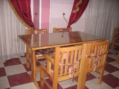 a dining room table and chairs with a glass top at Obelisk house in Jazīrat al ‘Awwāmīyah