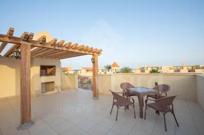 a patio with a table and chairs on a balcony at Ladybird - Veranda Skyline in Hurghada