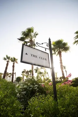 a sign for the club with palm trees in the background at Ladybird - Veranda Skyline in Hurghada
