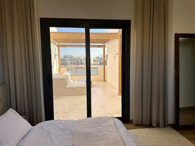 a bedroom with a bed and a view of a balcony at Charming 3BR Villa/Free Pool & Lagoon Access@Gouna in Hurghada