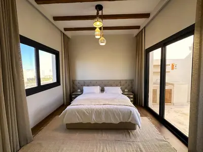 a bedroom with a large bed and large windows at Charming 3BR Villa/Free Pool & Lagoon Access@Gouna in Hurghada