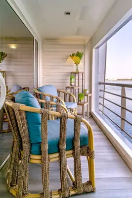 a room with a rattan chair on a balcony at Sonesta Sun Goddess Cruise Ship From Luxor to Aswan - 04 & 07 nights Every Monday in Luxor