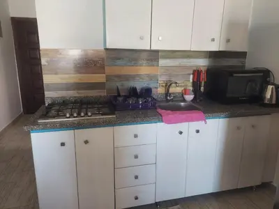 a kitchen with white cabinets and a counter top at Makramia 2 bedroom apartment in Hurghada