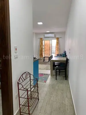 a chair in a living room with a piano at Makramia 2 bedroom apartment in Hurghada