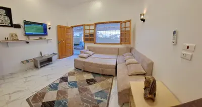 a living room with a couch and a television at Amenhotep Apartments in Luxor