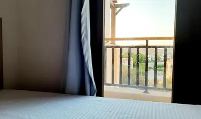 a bedroom with a bed and an open window at Joka Aldau Heights in Hurghada