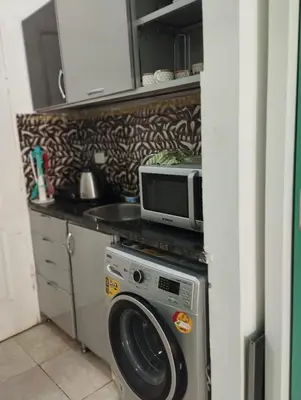 a kitchen with a microwave and a washing machine at plaza hurgahda in Hurghada